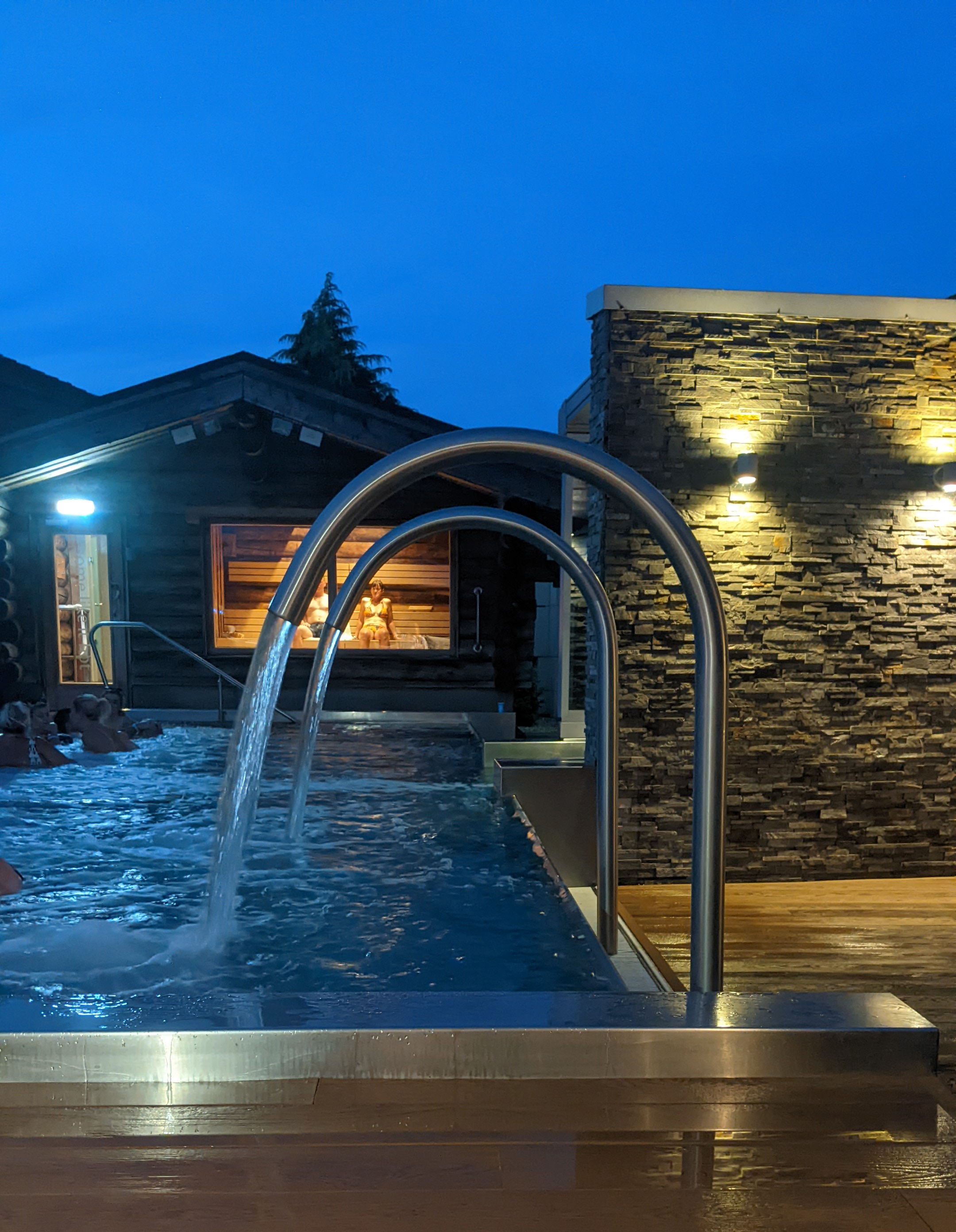 evening outdoor spa pool with water jets and people