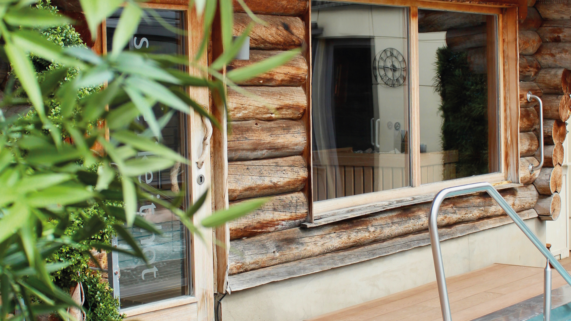 wooden log cabin door and window with metal handrail