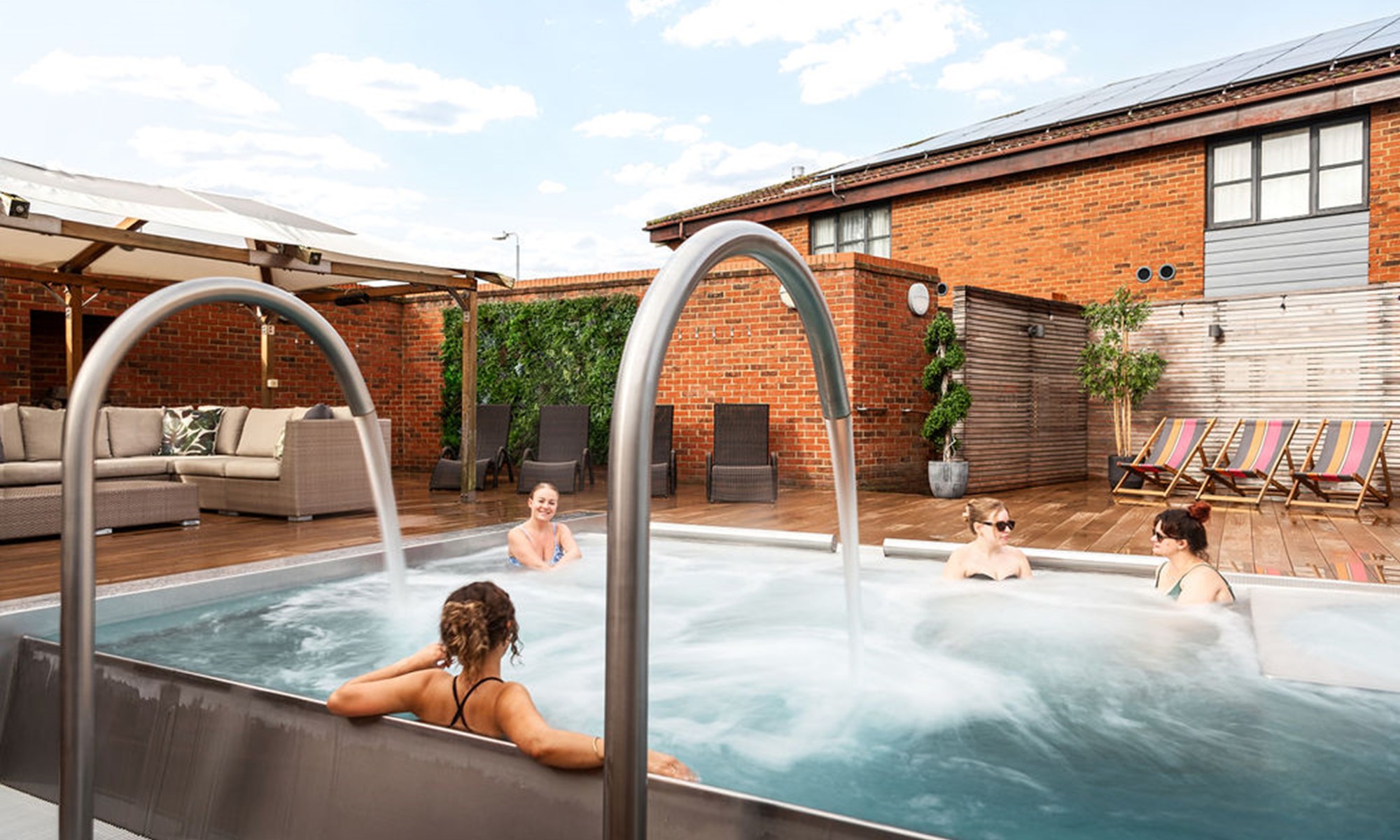 four women relaxing in outdoor jacuzzi pool area