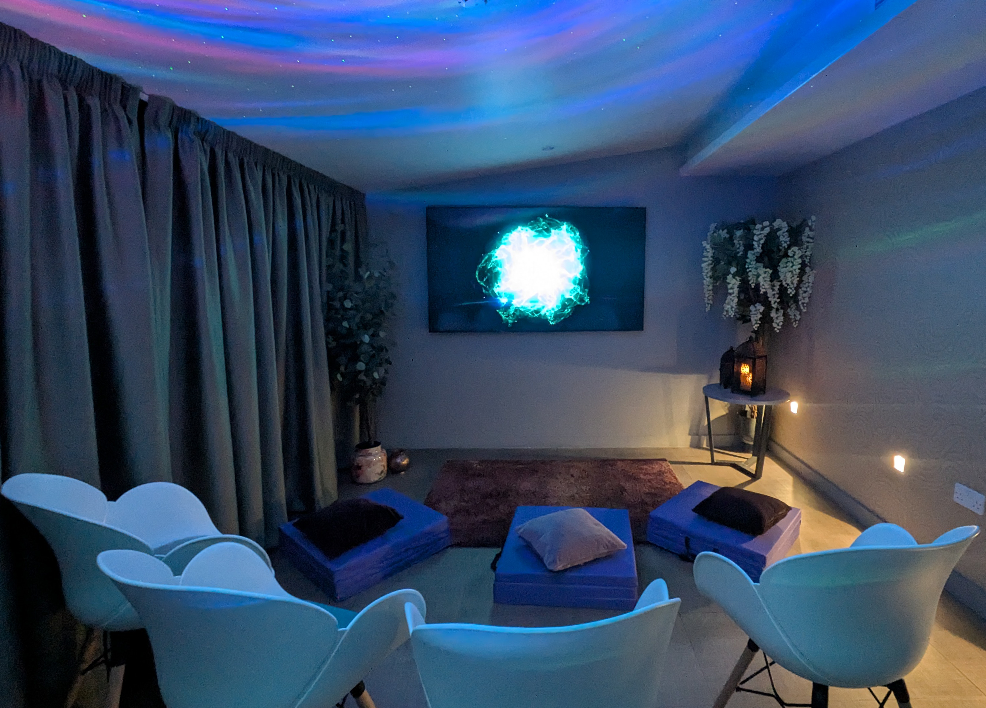small home cinema with white chairs and purple cushions